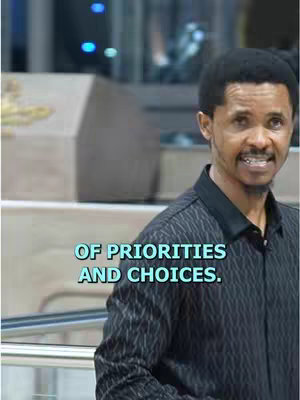 A man in a black patterned shirt is centered against a blurred background. The text overlayed says "OF PRIORITIES AND CHOICES." The text is in a light teal.