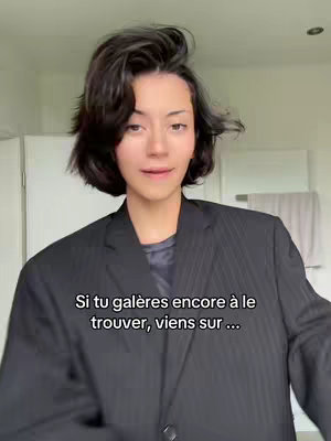 The image features a person with short, dark hair in a black blazer, shot from the chest up against a neutral background. The person looks towards the camera. Text overlaid on the image says "Si tu galères encore à le trouver, viens sur ..."