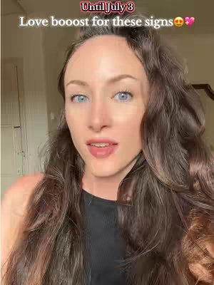 A woman with long, wavy brown hair is centered in the frame, looking towards the camera. Text overlay is present at the top. The background suggests an indoor setting with a neutral color scheme. The woman is wearing a black top.