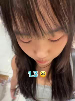 A close up of a person looking down with a somewhat sad expression. The overlay shows a number 1.3 followed by a pleading face emoji.