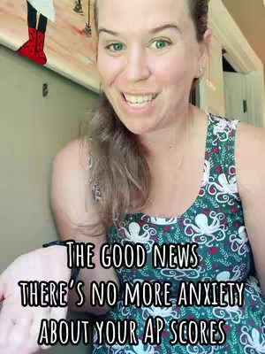A woman with fair skin and light brown hair is centered in the frame, smiling at the camera. She wears a patterned green dress. Text overlays with a black background read "THE GOOD NEWS THERE'S NO MORE ANXIETY ABOUT YOUR AP SCORES". The background shows a portion of what appears to be a painting and a glimpse of a door or a room.