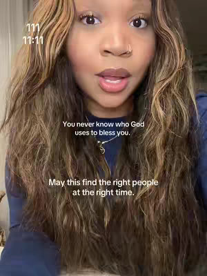 A close-up shot of a woman with long, wavy brown hair. Text overlays are added. The woman has a gentle expression and is looking straight at the camera. The background is blurred.