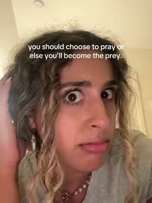 A close-up shot of a woman with her eyes wide, showing surprise, set against a neutral background. The text overlay states: 'you should choose to pray or else you'll become the prey.' The woman's hair is wavy and light brown, and she wears a light-colored shirt and a necklace. Her gaze is directed towards the camera.