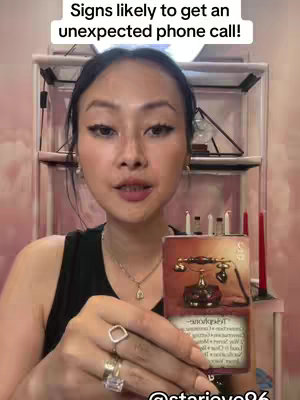 A woman with dark hair is holding a tarot card with a telephone design, in front of a bookshelf and pinkish background. The top of the image has white text.