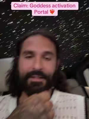 A selfie-style video featuring a man with long dark hair and a beard, appearing to be in a car. He has a pink and white text overlay at the top, and the background features small white lights, possibly the car ceiling.
