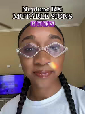 A selfie-style shot featuring a person wearing diamond-shaped glasses with the text 'Neptune RX: MUTABLE SIGNS' overlaid at the top. The person has long braided hair, and a white shirt.