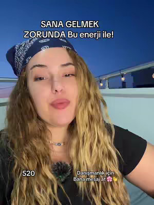 A woman with long wavy blonde hair is featured in a selfie style shot, framed from the chest up. She is wearing a black top and a blue bandana with a pattern. The background is a blurry view of a dusk or night sky. Text overlays are present, and she appears to be speaking or addressing the camera directly.