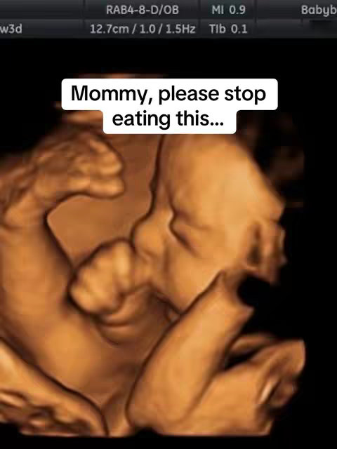 The image shows a 3D ultrasound scan of a fetus in the womb. The fetus is visible in shades of brown and tan against a black background. The text overlayed on the image reads 'Mommy, please stop eating this...'