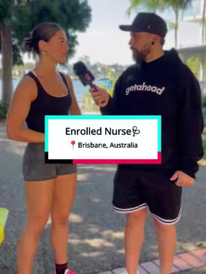 A man and woman stand outdoors, the man holding a microphone and interviewing the woman. They are set against a blurred background of greenery and water. A text overlay indicates the video's topic: Enrolled Nurse, Brisbane, Australia.