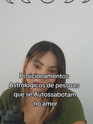 A woman with medium-length brown hair and bangs is centered in the shot. She is wearing a green top, with text overlayed in the middle that reads "Posicionamentos Astrológicos de pessoas que se Autossabotam no amor". Above her, a minimalist design of three crescent moon shapes are visible against a solid white background. The overall composition is a straightforward portrait with text, suitable for social media.