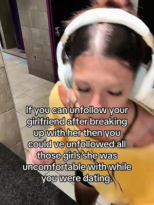 The cover image features a close-up shot of a woman's face. She's wearing white headphones and a yellow top, with the focus on her face and head. The background is blurred, and overlaid text provides context, suggesting the content is about breakups.