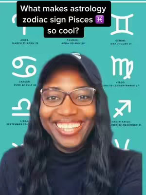 A selfie style shot of a Black woman smiling at the camera. The background has a teal color and displays different zodiac signs around her. A black text box overlays the top of the frame.
