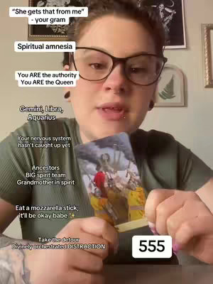 A woman with glasses looks into the camera, holding a tarot card. Text overlays include phrases about the tarot and a countdown of '555'. The background is a room with framed pictures.