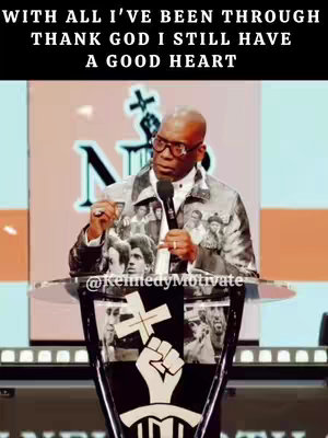 A man in a patterned jacket speaks from behind a podium. Text overlays the top of the image.