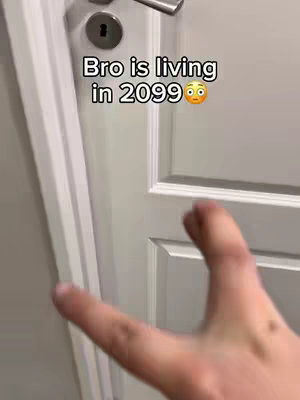 The cover image presents a first-person view of a hand reaching towards a white door. Above, text overlaid, reads 'Bro is living in 2099' with an emoji. The composition gives a sense of suspense and anticipation.