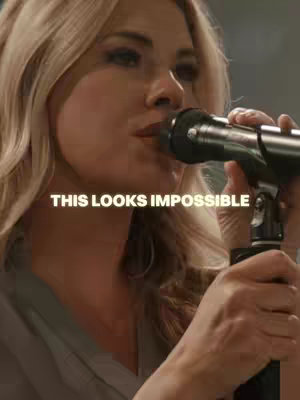 A woman with blonde hair holds a microphone near her mouth. The words 'THIS LOOKS IMPOSSIBLE' are overlaid on the image.