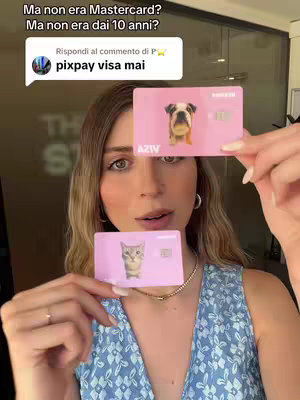 A young woman with long blonde hair holds two pink credit cards, one with a bulldog image and the other with a cat. She is wearing a blue floral top, and the background is slightly out of focus. A speech bubble appears in the top left corner with text on it.