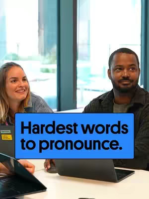 The cover image shows two people, a woman and a man, sitting at a desk with laptops angled towards them. The man is the main focus. A blue rectangle overlaid on the image contains the text, "Hardest words to pronounce."