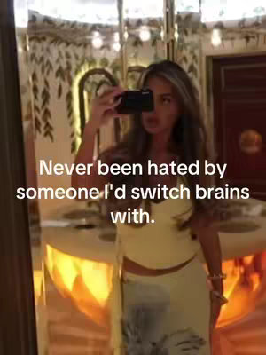 A woman holding a phone up to take a selfie in front of an ornate mirror, with text overlayed.