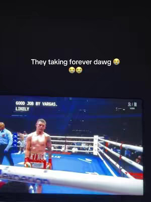 The image shows a screen displaying a boxing match. The text is overlaid on the image. A boxer is standing in the boxing ring, and text at the top of the screen reads, and the text reads 'They taking forever dawg', with two emoji faces.