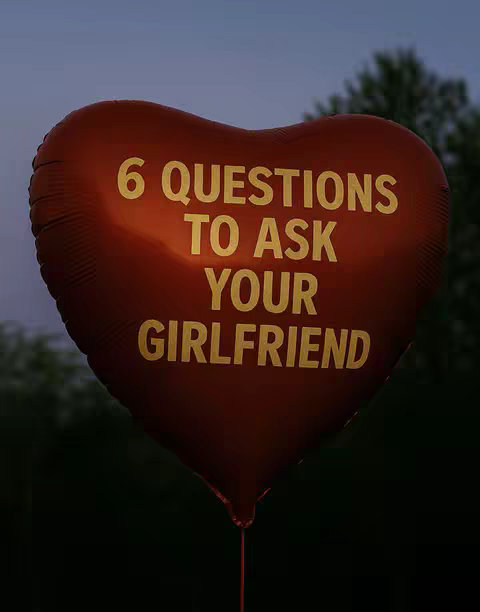 A heart-shaped red balloon against a dark background with text overlaid. The balloon is illuminated, with the surface reflecting the light. The background is a blurred image of trees and the evening sky.