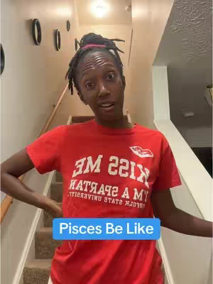 The cover image shows a woman standing on a staircase, looking at the camera with a thoughtful expression. She is wearing a red t-shirt. A text overlay that reads "Pisces Be Like" is placed on the lower part of the image. The background includes a staircase, railings, and interior design elements.