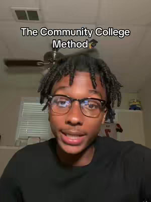 A young Black man with short dreadlocks, black-framed glasses, and a black shirt is centered in the frame. Above him, a text overlay reads 'The Community College Method.' The background subtly shows a ceiling and a glimpse of a fan, suggesting an ordinary indoor setting.