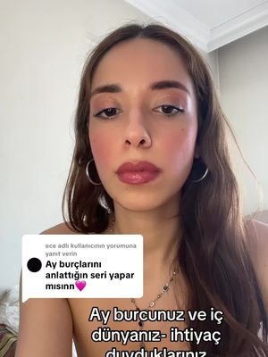 A selfie-style video cover image featuring a light-skinned woman with brown hair and a neutral expression. She is wearing hoop earrings and makeup, including blush and lip color. Text overlays appear on the image, including a comment box with text and another text overlay related to astrology.