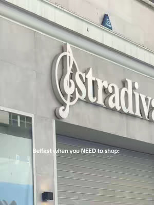 The image features a building facade with the large, white text "Stradivarius" in a stylized font and logo. Below the text are closed metal shutters. The image has a muted color palette, primarily consisting of gray, white, and a touch of blue. The composition is a medium shot, focusing on the store's exterior details.