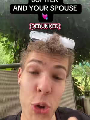 A selfie-style video cover with a young man in the foreground looking at the camera with a slight smile. Overlaid at the top is a black banner with white text, and in the center an image of a pink heart with a blue heart. Background details are slightly blurred, suggesting an outdoor setting like a patio.