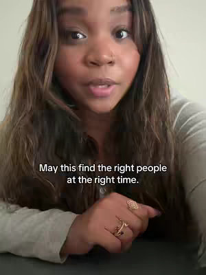A medium shot captures a young woman from the chest up, centered against a neutral, blurred background. Her brown hair is styled with soft waves, and her gaze is directed toward the viewer with an expressive expression. She's wearing a light-colored top, and her hand is subtly raised, showing off rings. Text overlayed features the text 'May this find the right people at the right time.'