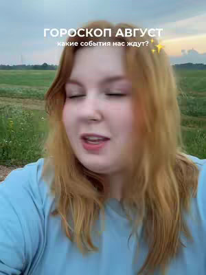 A selfie-style shot with a woman at center, looking toward the left. The background shows a field under a somewhat cloudy sky. Overlaid text, in white, is near the top. The woman is wearing a light blue shirt.