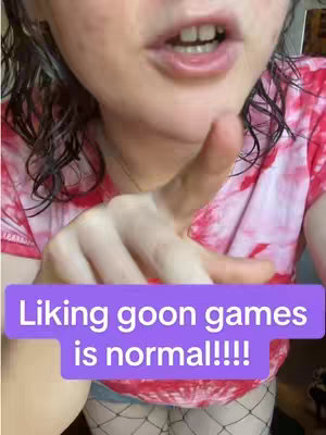 Upper body shot in a close-up, featuring a person pointing towards the viewer. The person is wearing a tie-dye pink and red shirt and fishnet stockings. A purple rectangle with white text overlay is present in the image.