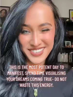 The cover image features a close-up of a smiling woman with long, dark hair and heterochromia (different colored eyes). She is positioned in the center of the frame, with a blurred background showing books and other objects. Text overlayed on the image promotes manifestation and visualizing dreams.