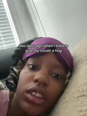 The cover image shows a close-up of a person looking directly at the camera. The person has dark skin and is wearing a dark bonnet and a purple head covering. Their eyes are open, conveying a look of moderate surprise or concern. The background appears to be a blurry, neutral setting, potentially indoors. The text overlay is in white font, narrating an event.