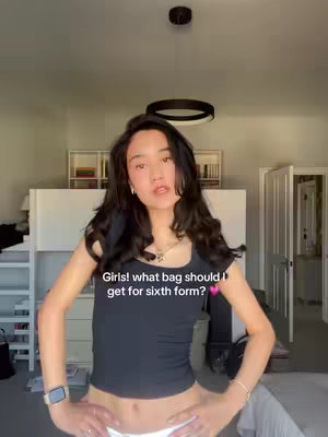 A young woman stands centered in a bedroom, arms at her sides, a smartwatch on her wrist. The background includes a bedroom wall, a bed, and a ceiling light. Text is overlaid on the image asking for advice.