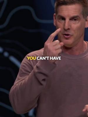 A medium shot shows a man on a dark background, possibly a studio setting. The man is pointing near his eye. Overlayed yellow text reads, 'YOU CAN'T HAVE'. The man wears a muted brown long-sleeved shirt.