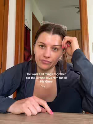 A woman with brown hair is sitting in front of a wooden table with her arms and finger pointing forward. Text overlay over the image.