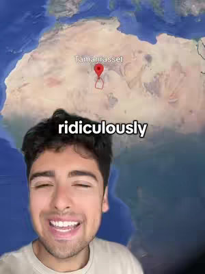 A man with dark hair is smiling at the camera. Behind him is a map of Africa with a red location tag pointing to the city of Tamanrasset in Algeria, and the text overlay says 'ridiculously'.