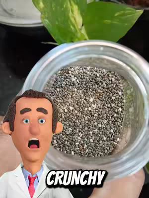 A 3D-animated doctor figure with a surprised expression, framed in front of a jar filled with chia seeds, with a background of greenery and a clear container. The text'CRUNCHY' is overlaid at the bottom.