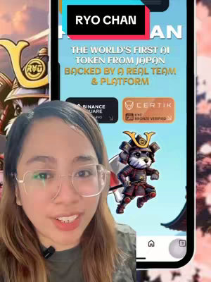 The cover image shows a woman in front of a phone screen. The screen displays marketing material for a cryptocurrency project featuring a cartoon samurai dog. The top of the screen has a black bar with white text \"RYO CHAN\". The foreground shows the woman in glasses, looking at the camera with an open mouth. She appears to be talking. On the left of the background there’s a blurred samurai and on the right the samurai dog artwork.