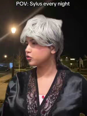 A person with light skin and gray hair wearing a black robe. A street light is in the background with the night sky. The text'POV: Sylus every night' is on the top of the image.