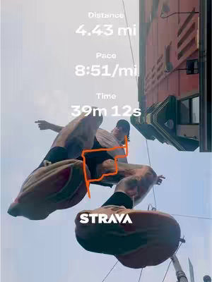 An eye-level shot shows a man running on top of a building. Below the man is the word "STRAVA" in white text. Above the man is text indicating "Distance 4.43 mi", "Pace 8:51/mi", and "Time 39m 12s."