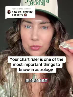 A woman with long, wavy hair wearing a baseball cap and light-colored, striped shirt is looking directly at the camera, with the front-facing shot highlighting her face and upper body. Overlaid towards the bottom of the image are two text boxes with information. One contains the information in a speech bubble with a profile image, the second one says, "Your chart ruler is one of the most important things to know in astrology" and contains the words 'AM GOING TO HOST' is written inside a red box below it.