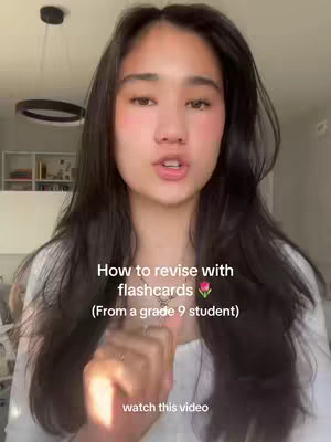 A young woman with long dark hair is speaking directly to the camera. Text overlays describe how to revise using flashcards.
