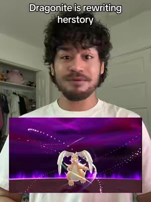 A selfie-style video setup with a man in the foreground, a Pokemon display, and background elements indicating a room with clothes. Text overlay reads "Dragonite is rewriting herstory."