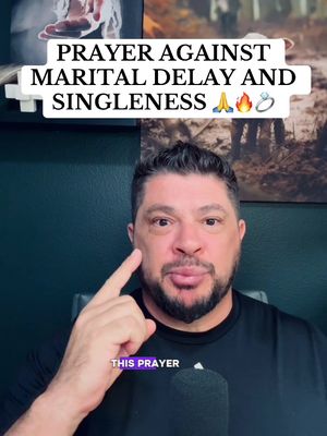 The cover image features a man in a medium close-up, centered in the frame. He has short, dark hair and a neatly trimmed beard with a slightly serious expression. His index finger is pointing towards his cheek. Above him, a text overlay reads, "PRAYER AGAINST MARITAL DELAY AND SINGLENESS", with symbols of praying hands, fire and a ring. In the background, slightly blurred, there are images of people and nature scenes, possibly representing the themes of love and relationships. The overall composition is a mix of studio-style lighting and informal feel, with the muted background images creating depth and adding context.
