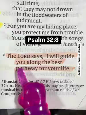 A close-up shot of an open book with text and a finger with a highlighter. The text, highlighted in light orange/yellow, is a Bible verse. A black rectangular text box that reads "Psalm 32:8" is in the middle of the image.