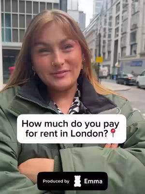A woman in a green jacket stands in front of a city street, smiling and looking at the camera. The background suggests a European city, with buildings, and blurred vehicles. A text overlay asks viewers about rent prices in London. The video is branded with the 'Emma' logo.