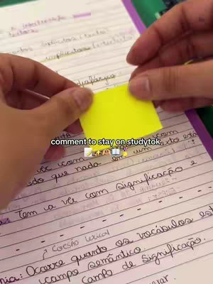The cover image shows a close-up of someone's hands writing on a notebook. The person is holding a yellow sticky note with writing, possibly a reminder or a note. Beside the note is a notebook with handwritten notes and text written in Portuguese.